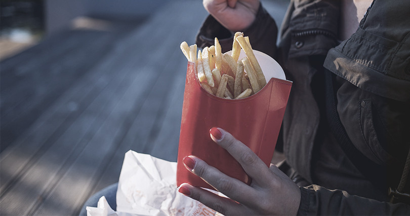 A women snacks on some french fries