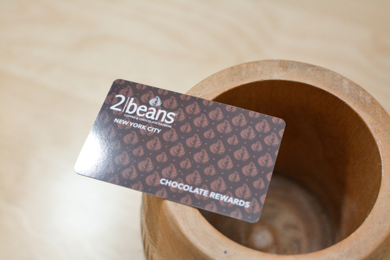A dark brown pattern design used on plastic cards for a chocolate and coffee shop