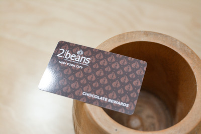 A dark brown pattern design used on plastic cards for a chocolate and coffee shop
