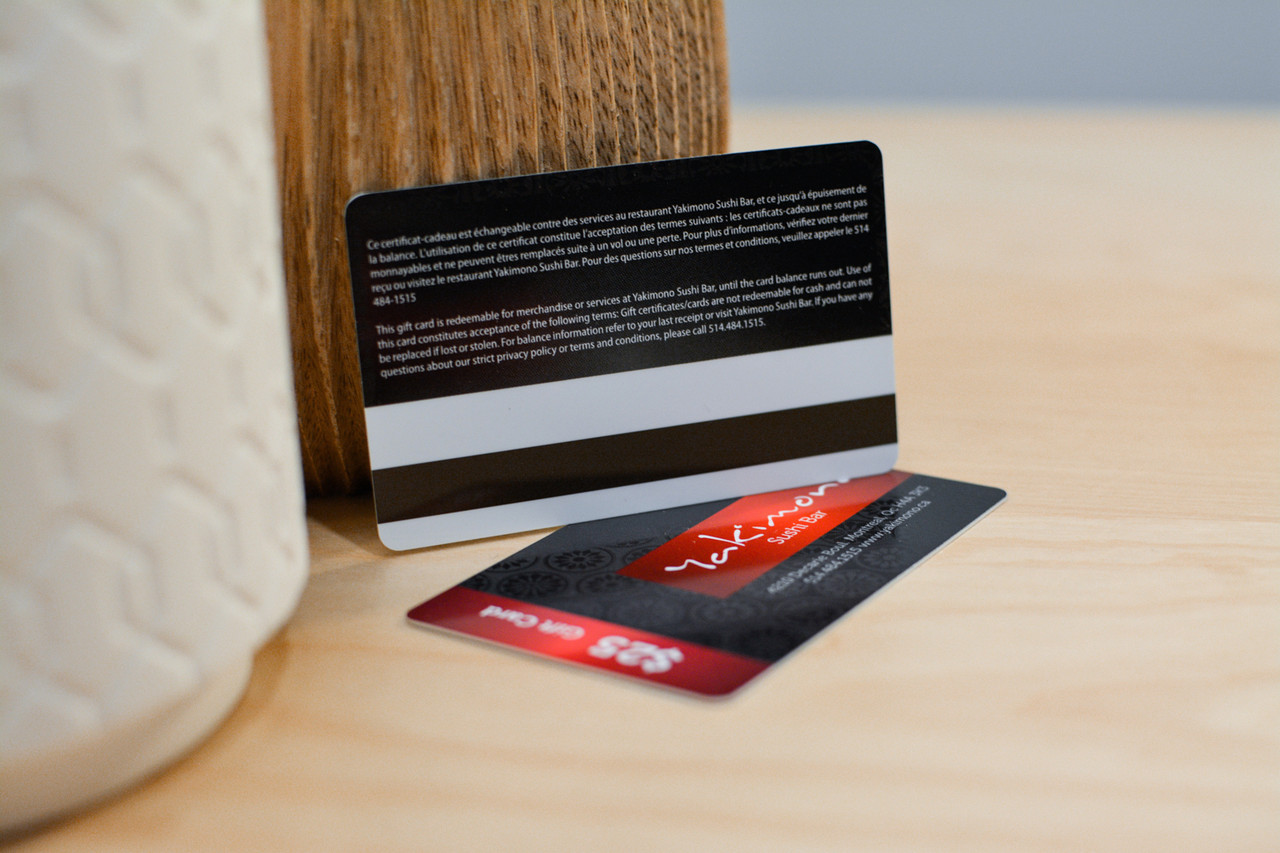 A card with several small logos used by a restaurant group showing a magnetic encoding stripe