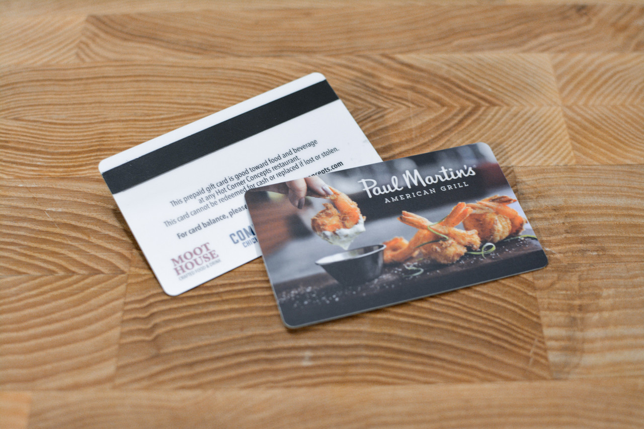 A dark gray plastic gift card design with a large dollar sign