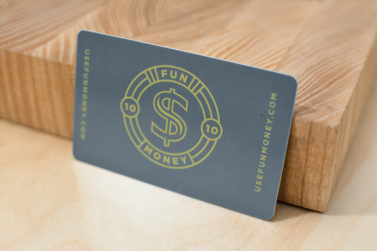A dark gray plastic gift card design with a large dollar sign