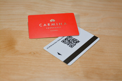 A bright red design with a metallic logo on the front and a QR code on the back